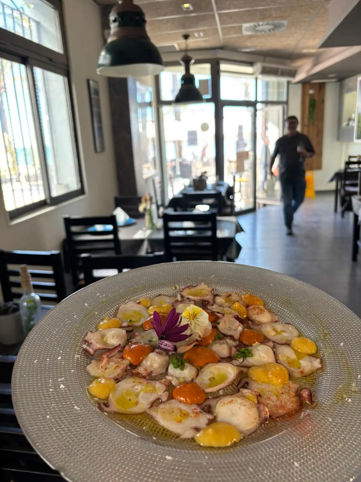 Delicioso pulpo a la brasa con emulsiones en Pulpería Arrocería el Poal, Vinaròs. Disfruta de tapas mediterráneas con vistas al mar.