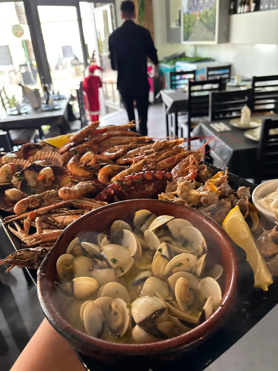 Parrillada de mariscos en Pulpería Arrocería el Poal, Vinaròs, con variedad de mariscos frescos y almejas al vapor, destacando la cocina mediterránea.